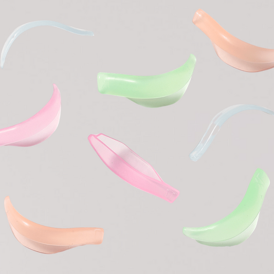 Pads colorés pour lash lift en silicone souple, utilisés pour rehaussement de cils professionnels, disposés sur fond neutre.